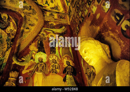 Replicas of Buddha statues are displayed in a replicated chamber of the Mogao Grottoes during the Dunhuang Art Exhibition at Zhejiang Art Museum in Ha Stock Photo