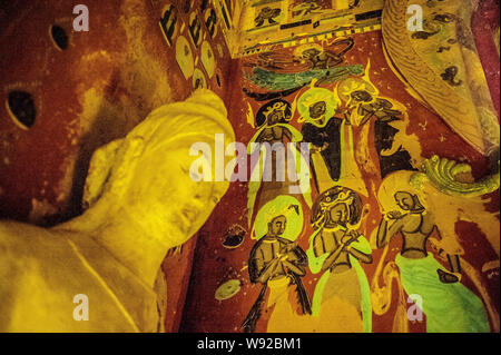 Replicas of Buddha statues are displayed in a replicated chamber of the Mogao Grottoes during the Dunhuang Art Exhibition at Zhejiang Art Museum in Ha Stock Photo