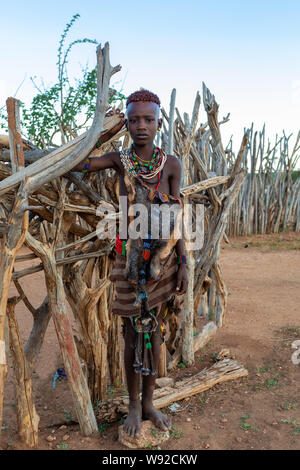 Turmi, Omo River Valley, Ethiopia - May 10, 2019: Portrait of a Hamar teenager in village. The Hamer are a primitive tribe and the women have many dec Stock Photo