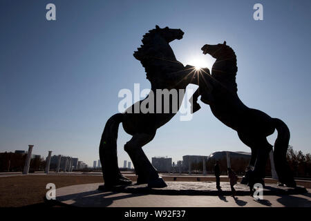 --FILE--People stand in front of horse sculptures on the square in Kangbashi district, Ordos city, north Chinas Inner Mongolia Autonomous Region, 16 D Stock Photo