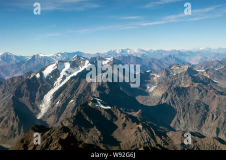 Andean mountain range with mountains peaks covered under snow, aerial view of Andes from the plane window Stock Photo