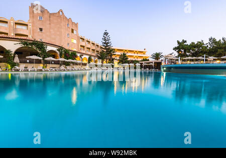 RHODES, GREECE - JULY 24, 2019: Kalithea Mare Palace, Luxury Hotel Resort with Swimming Poll Illuminated at Sunrise Stock Photo
