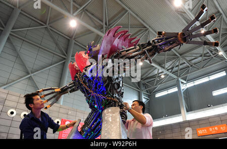 Chinese fans examine and test a robot made from auto scraps in the shape of a figure from the movie series, Transformer, at Hefei Binhu International Stock Photo