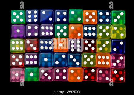 many tranlucent multicolored dices in rows on black background Stock Photo