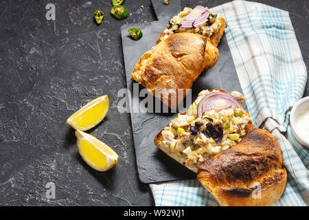 Fish pate, minced herring fillet with apple and egg on toasted rye bread, homemade traditional Jewish cuisine dish forshmak on black stone table Stock Photo