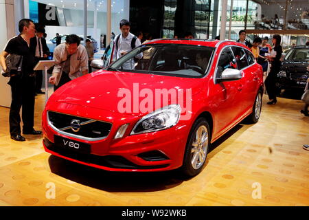 --FILE--Visitors look at a Volvo V60 during the 10th China (Guangzhou) International Automobile Exhibition, known as Auto Guangzhou 2012, in Guangzhou Stock Photo