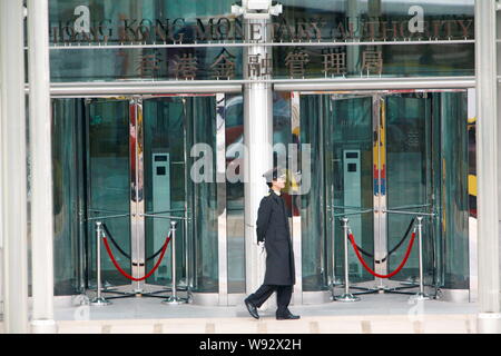 --FILE--A security guard walks past the closed doors at the Hong Kong Monetary Authority (HKMA) in Hong Kong, China, 4 December 2010.   The global rat Stock Photo