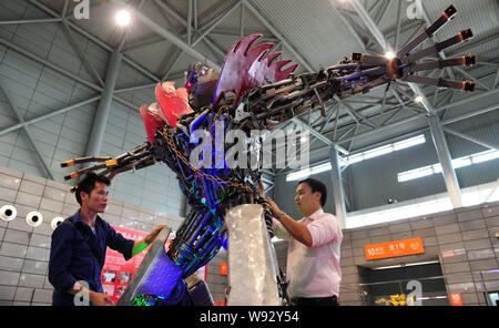 Chinese fans examine and test a robot made from auto scraps in the shape of a figure from the movie series, Transformer, at Hefei Binhu International Stock Photo