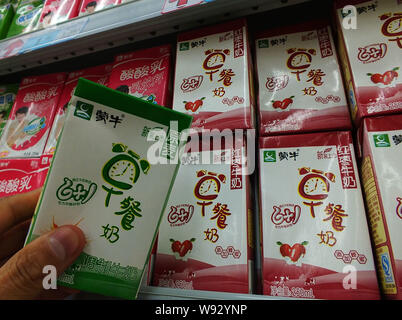 --FILE--A Chinese customer shops for Mengniu milk at a supermarket in Yichang city, central Chinas Hubei province, 27 March 2013.   China Mengniu Dair Stock Photo