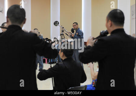 A Chinese inmate uses a camcorder to take videos of a performance to celebrate the 10th anniversary of Tianhe TV Station at Tianhe Prison in Beijing, Stock Photo