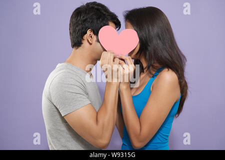 Couple Kissing Behind Heart Shape Stock Photo - Alamy
