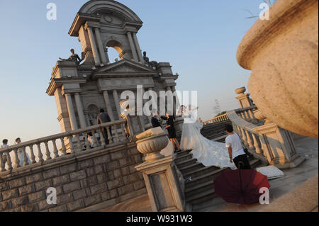 Young Chinese couples pose for wedding photos in front of a Parisian-style architecture at Tianducheng, a small Chinese community replicating Paris, i Stock Photo