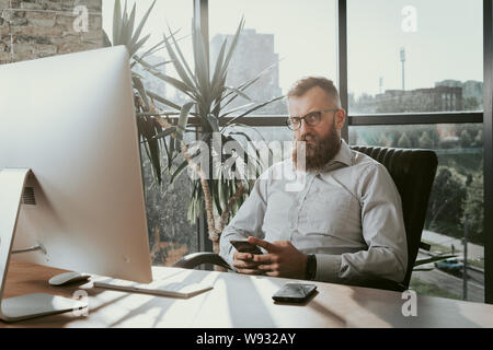 Portrait Of Businessman At Office Desk Using Computer. Stock Photo