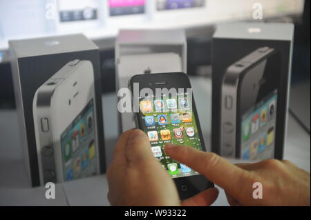 --FILE--A customer tries out an iPhone smartphone in an authorized store of Apple in Qionghai, south Chinas Hainan province, 2 April 2013.   Early Mon Stock Photo