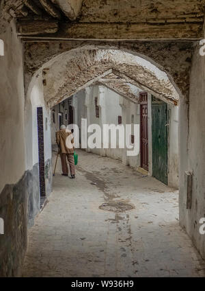 Tetuan, Morocco, Africa - February 15, 2016: Passage in the medina of Tetuan, with an old man on his back walking in the passage
