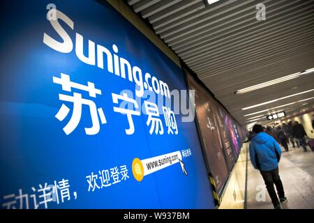 --FILE--Pedestrians walk past an advertisement for online shopping site Suning.com in Beijing, China, 12 January 2013.   Chinese electronics and home Stock Photo