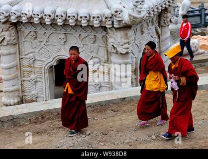 Local lamas walk past the tower of silence after a sky burial in Sertar county, Ganzi Tibetan Autonomous Prefecture, southwest Chinas Sichuan Province Stock Photo