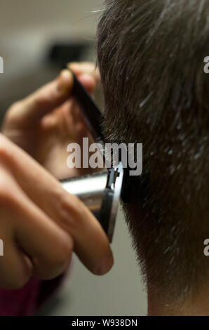 Hairdresser cutting mans grey hear with clipper, hands, close up Stock Photo
