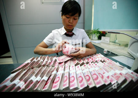 --FILE--A Chinese clerk counts RMB (renminbi) at a branch of Industrial and Commercial Bank of China (ICBC) in Huaibei, east Chinas Anhui province, 9 Stock Photo