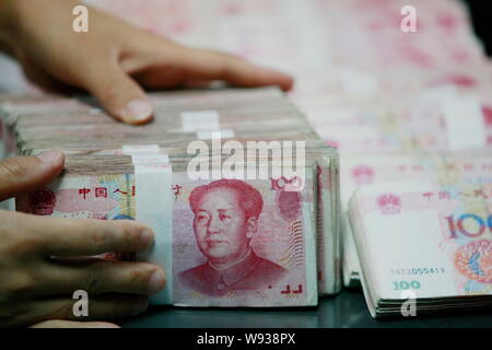 --FILE--A Chinese clerk counts RMB (renminbi) at a branch of Industrial and Commercial Bank of China (ICBC) in Huaibei, east Chinas Anhui province, 9 Stock Photo
