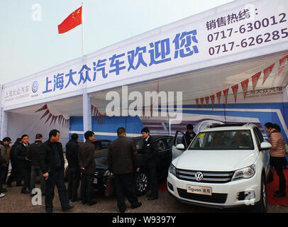 --FILE--Visitors look at a Tiguan and other cars of Shanghai Volkswagen, a joint venture between SAIC and VW, during an auto show in Yichang city, cen Stock Photo