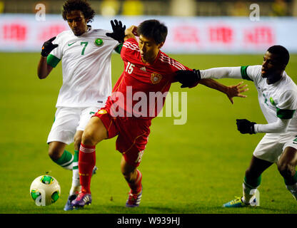 Jiang Ning of China, center, challenges Yasser Al-Shahrani, left, and Mansoor Al-Harbi of Saudi Arabia during their Group C match of the AFC Asian Cup Stock Photo