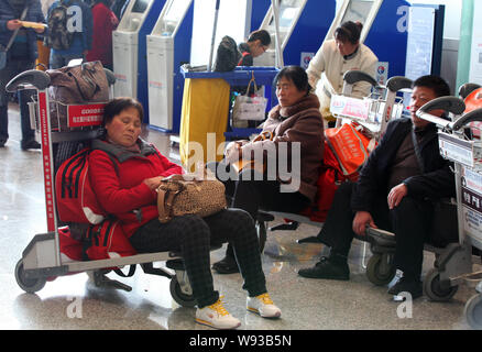 Chinese passengers wait after their flights were postponed or cancelled due to the heavy snow at the Kunming Changshui International Airport in Kunmin Stock Photo