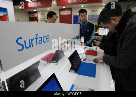 --FILE--Chinese shoppers try out Microsoft Surface Pro tablet PCs at a home appliances store in Shanghai, China, 3 April 2013.     Microsoft Corp.s af Stock Photo