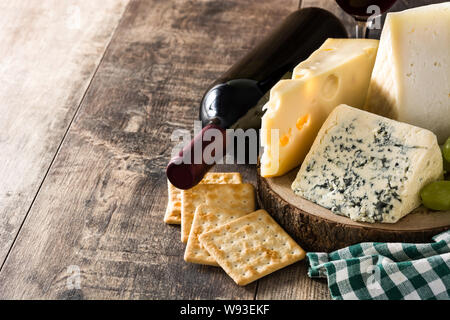 Assortment of cheeses and wine on wooden table. Copyspace Stock Photo