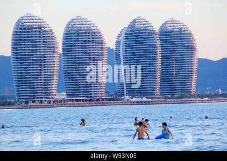 --FILE--People swim in the sea near Phoenix Island in Sanya city, south Chinas Hainan province, 19 July 2012.   Prices on Phoenix Island, a man-made i Stock Photo