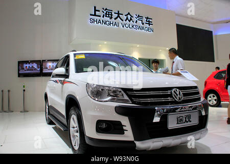 --FILE--Visitors look at a Tiguan of Shanghai Volkswagen, a joint venture between SAIC and VW, during an auto show in Haikou city, south Chinas Hainan Stock Photo