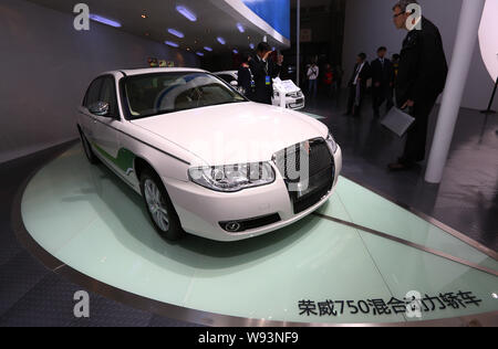 Visitors look at a Roewe 750 Hybrid of SAIC Motor during the 15th Shanghai International Automobile Industry Exhibition, known as Auto Shanghai 2013, Stock Photo