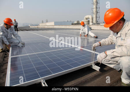--FILE--Chinese workers install solar panels on the rooftop of factory building of Zhejiang Jinbei Science and Technology Co., Ltd. in Tonglu city, ea Stock Photo
