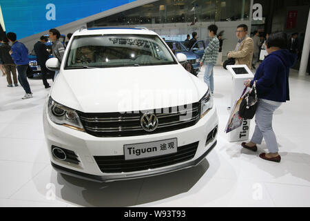 Visitors look at a Tiguan of Shanghai Volkswagen, a joint venture between SAIC and VW, during the 15th Shanghai International Automobile Industry Exhi Stock Photo