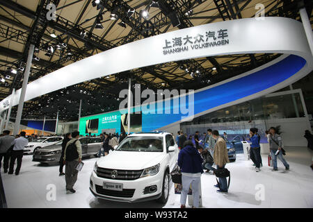 --FILE--Visitors look at a Tiguan SUV and other cars at the stand of Shanghai Volkswagen, a joint venture between SAIC and VW, during the 15th Shangha Stock Photo