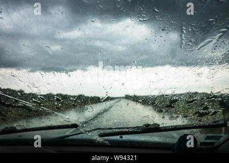 drivers view of heavy rain through car window Stock Photo