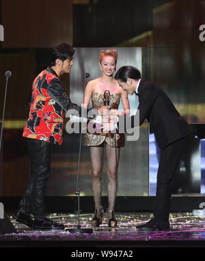 Taiwanese singer Jam Hsiao, right, receives a trophy from Taiwanese singer Jay Chou, left, and Jolin Tsai during the award ceremony of the 24th Golden Stock Photo