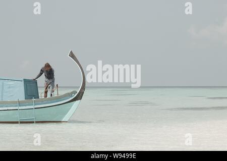 Ari Atoll, Maldives - 25 December 2018: A maldivian sailor is fishing on his boat Stock Photo