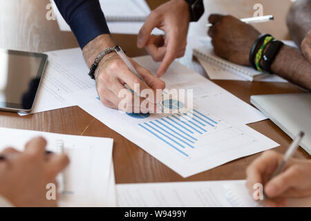 Close up of diverse business people working with financial report Stock Photo