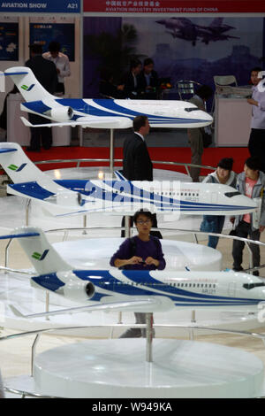 --FILE--Visitors look at models of the Chinese-developed ARJ21 regional jet of COMAC (Commercial Aircraft Corporation of China, Ltd.) during the 2011 Stock Photo