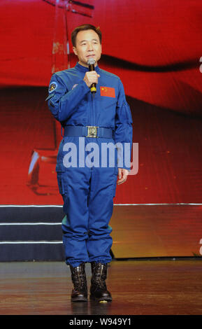 Chinese astronaut Jing Haipeng speaks from behind a glass enclosure ...