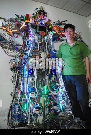 Chinese farmer Tao Xiangli poses with his robot made from scrap at home in Beijing, China, 16 May 2013.   Tao Xiangli, a 37-year-old inventor from Bei Stock Photo