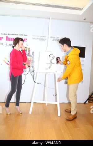 Hong Kong actor Aarif Lee, right, looks at the portrait that South Korean actress Ku Hye Sun, left, drew for him at the opening event for Kus solo art Stock Photo