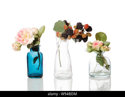 Flowers and herbs in glass bottles. Abstract flower bouquets in bottles isolated on white Stock Photo