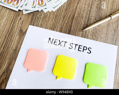 Clipboard with text next step on wood desk. Stock Photo