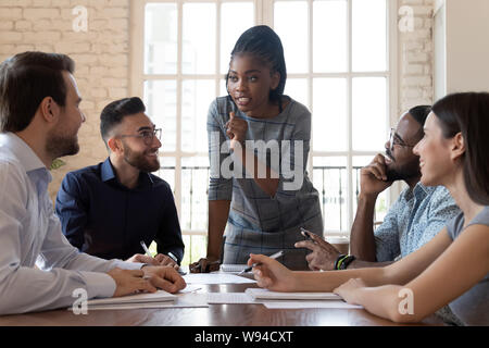 Female black executive talking to diverse employees at office briefing Stock Photo