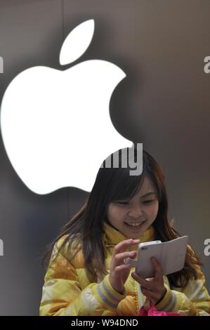 --FILE--A customer tries out iPhone smartphone at an Apple Store in Shanghai, China, 1 January 2013.    Apple Inc. (AAPL) introduced installment payme Stock Photo