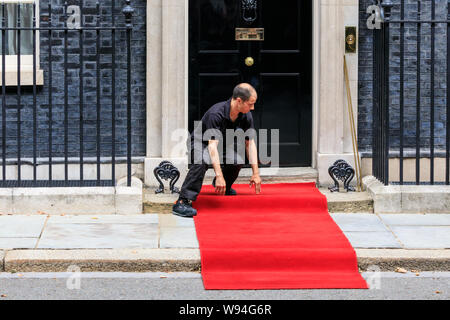 A red carpet is being installed and prepared outside No 10 Downing Street for a Head of State visit, London, UK Stock Photo
