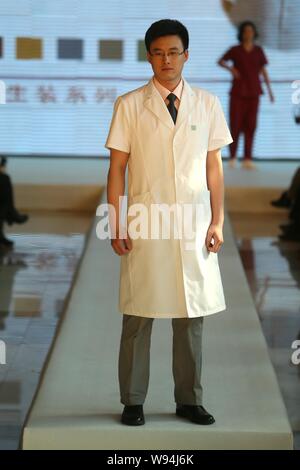 A Chinese doctor displays a new hospital uniform during a fashion show in Beijing, China, 1 April 2013.   A special fashion show was held at a hospita Stock Photo