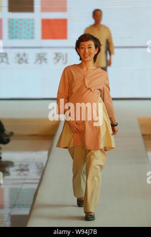 A pregnant woman displays a new hospital uniform during a fashion show in Beijing, China, 1 April 2013.   A special fashion show was held at a hospita Stock Photo